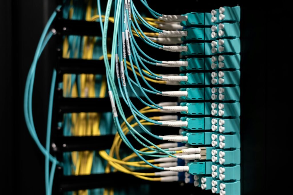 Closeup of electronic device with colorful wires installed in rows in communications room on blurred background in dark studio inside