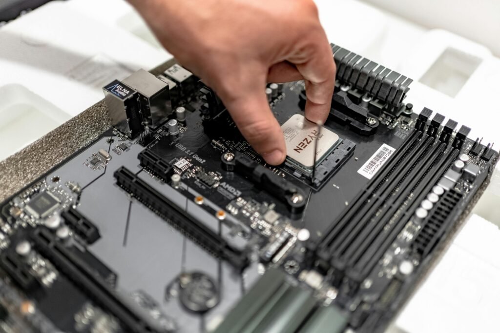 Person's hand installing a CPU on a motherboard, showcasing PC maintenance and repair.